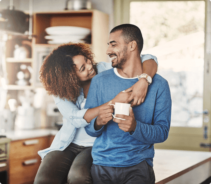 a couple sitting on counter drinking coffee