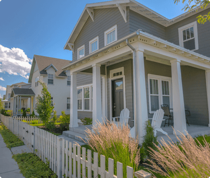 A street lined with houses and white picket fences