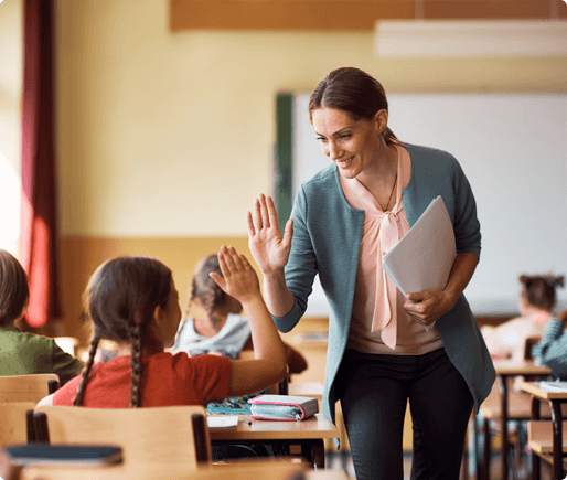 A teacher high fiving a student in the classroom