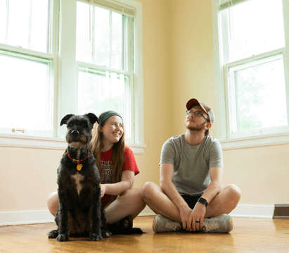 family and dog sitting on floor at home
