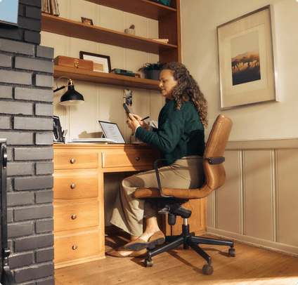 A woman sitting at a desk using her phone
