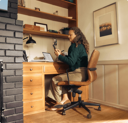 A woman sitting at a desk using her phone