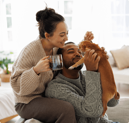 A couple playing with a puppy