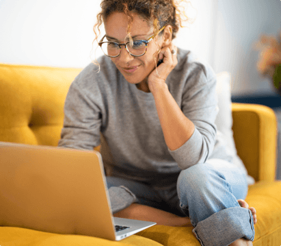 woman sitting on couch using laptop