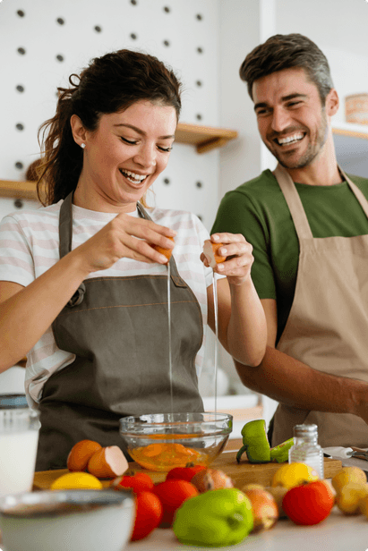 couple wearing aprons cooking together