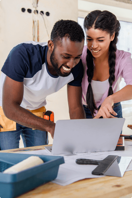 couple standing using laptop together